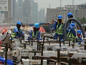 Foreign laborers work outside at the construction site of a track for the Dubai Metro, on 22 May 2013. (AFP/ Marwan Naamani)