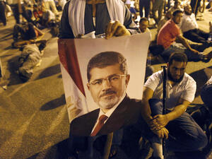  An Egyptian supporter of the Muslim Brotherhood holds a portrait of deposed president Mohamed Morsi during a rally outside Cairo's Rabaa al-Adawiya mosque late on July 7, 2013. (Source: AFP/MAHMOUD KHALED)