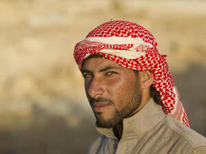 Bedouin camel herder wears a shemagh at sunset in Jordan (Shutterstock/Martin Good)