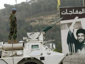 A UN peacekeeper is seen near Lebanon's Blue Line, with a picture of the Hezbollah leader Hassan Nasrallah in the background. (AFP/File)