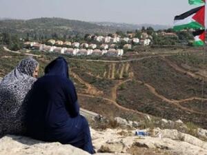 Two Palestinian women gaze at the Jewish Hallamish settlement in the West Bank village of Nabi Saleh (AFP/File Photo)	