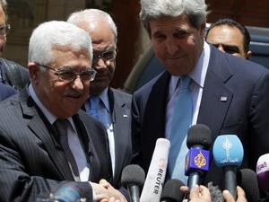 US Secretary of State John Kerry and Palestinian president Mahmoud Abbas shake hands as they speak to the press following their meeting at the Palestinian presidential compound in the West Bank city of Ramallah (Abbas Momani / AFP)