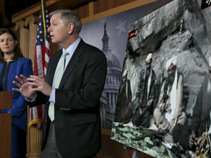 US Senator Kelly Ayotte talks about a photo of Sulaiman Abu Ghaith (L) during a press conference on Capitol Hill in Washington, DC. (AFP PHOTO/Brendan SMIALOWSKI)