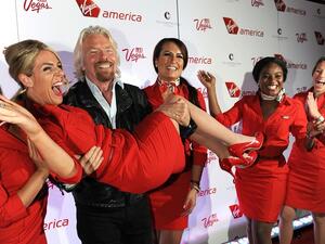 Virgin Group Founder Sir Richard Branson lifts a Virgin America staff member on April 22, 2013. (Virgin America/ Getty Images)