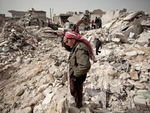 A Syrian man stands over the rubble of his house in Aleppo on February 23, 2013.  (AFP/Pablo Tosco)