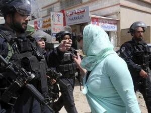 محتجة فلسطينية تصرخ في وجه افراد من الشرطة الاسرائيلية اثناء اشتباكات في الضفة الغربية
