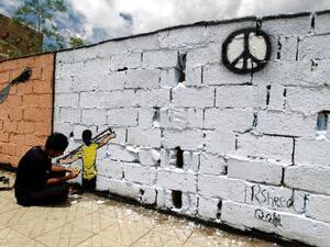 A Yemeni artist paints a wall in the capital Sanaa with a message of peace.  (AFP/File)
