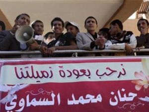طلاب يقفون اعلى لافتة ترحب بعودة الطالبة حنان السماوي الى جامعة صنعاء
