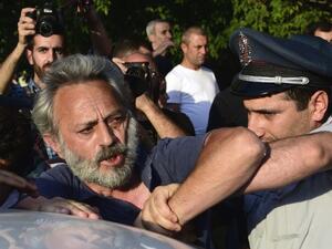 Armenian police detain an opposition supporter, artist Nikol Aghababyan, next to a police check point blocking the streets to Erebuni police station in Yerevan on July 17, 2016. (AFP/Karen Minasyan) Armenian police detain an opposition supporter, artist Nikol Aghababyan, next to a police check point blocking the streets to Erebuni police station in Yerevan on July 17, 2016. (AFP/Karen Minasyan)