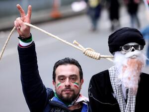 محتج يمسك بحبل مربوط برقبة دمية تمثل المرشد الاعلى الايراني علي خامنئي خلال وقفه في بروكسل تضامنا مع المتظاهرين في ايران