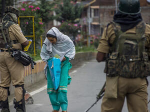 امرأة مسلمة تمر من بين جنديين هنديين في كشمير