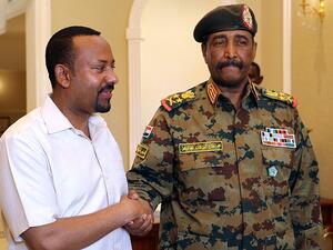 رئيس الوزراء الإثيوبي أبي أحمد (يسار) مصافحا رئيس المجلس العسكري السوداني عبدالفتاح البرهان غداة وصوله الى الخرطوم