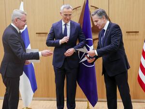 وزير الخارجية الاميركي انتوني بلينكن (يمين) يتسلم وثيقة انضمام فنلندا الى الناتو من وزير الشؤون الخارجية الفنلندي بيكا هافيستو، ويتوسطهما امين عام الحلف ينس ستولتنبرغ في بروكسل