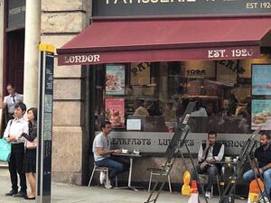 أمير قطر جالسا على طاولة على رصيف احد فروع سلسلة مقاهي لورد يعتقد انه في واشنطن