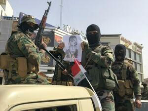 عناصر من مليشيا "ربع الله" يحملون صورة رئيس الحكومة العراقية مصطفى الكاظمي وعليها طبع حذاء