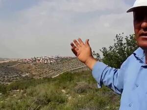احد سكان راس كركر يشير بيده ناحية مستوطنة قرب القرية