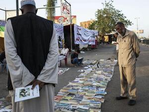 رجل سوداني يستعرض الصحف على احد الارصفة في الخرطوم