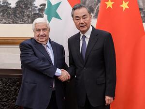 المعلم بجانب وزير الخارجية الصيني وانغ يي في بكين 