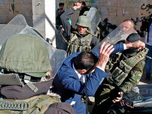 ارشيف/ عناصر من قوات الامن الفلسطينية يعتدون بالهراوات على متظاهر 