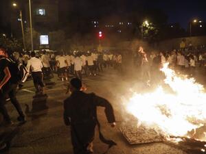 Ultra-orthodox Jews run as members of the Israeli Ethiopian community block the main entrance to Jerusalem  (AFP)