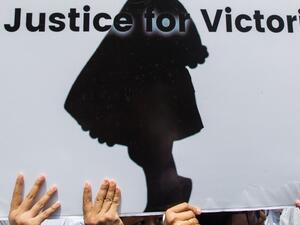 Protesters hold a sign during the demonstration demanding justice for a two-year-old who was raped and given the pseudonym "Victoria" in front of the Central Investigation Department (CID) in Yangon  (AFP)