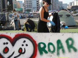 فتيات لبنانيات يزلن النفايات بعد التظاهرة