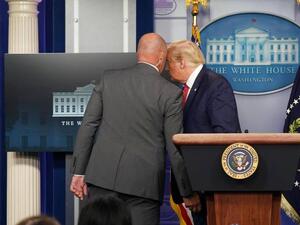 ترامب (يمين) اضطر لمغادرة قاعة المؤتمر الصحفي استجابة لإجراءات الحماية 