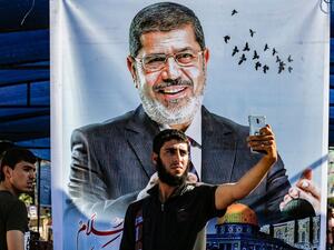 Egyptian youth wait outside a courthouse in which former Egyptian President Mohammed Morsi is on trial /AFP