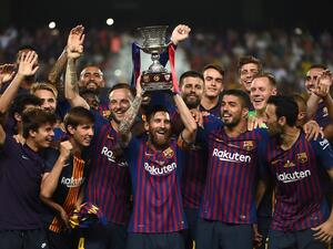 Barcelona's forward Lionel Messi (C) carries the Spanish Super cup after defeating Sevilla at Ibn Batouta Stadium in the Moroccan city of Tangiers. FADEL SENNA / AFP