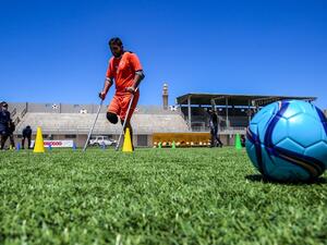 A Palestinian amputee using crutches participates in a football training in Gaza
