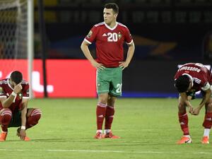 Moroccan players react after losing the penalty shoot-out
