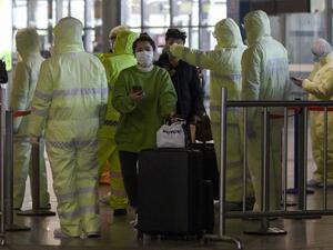 Medical workers wearing protective clothing check passengers' travel history at the Shanghai South railway station in Shanghai on February 9, 2020. AFP