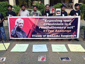 Activists stand behinf a banner and hold placards while forming a human chain calling for the freedom of the international non-profit organisation"WikiLeaks" founder Julian Assange, in Dhaka on April 23, 2019. (AFP)