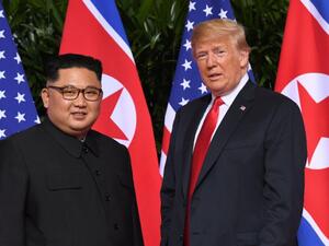 Standing in front of the flags of their two countries, Donald Trump and Kim Jong Un made history in Singapore (AFP Photo/SAUL LOEB)