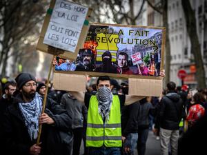 A man wearing a yellow vest (gilet jaune) holds a placard reading "we are going to do the revolution" as he takes part in a demonstration in Lyon on December 17, 2019 to protest against French government's plan to overhaul the country's retirement system, as part of a national general strike. (AFP/ File Photo)