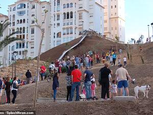 The chute saves a 10-minute walk from one street to another and it is reportedly Spain's biggest slide. (Daily Mail)