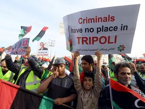 Libyans carry placards during a demonstration with yellow vests ("gilets jaunes") against strongman Khalifa Haftar in the capital Tripoli's Martyrs Square on April 19, 2019. (Mahmud TURKIA / AFP)