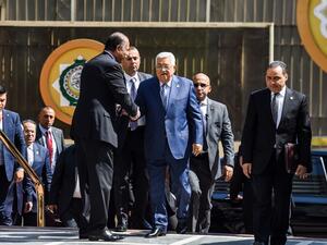 Palestinian president Mahmoud Abbas (C) is greeted upon his arrival at the Arab League headquarters in Cairo, on April 21, 2019. (MOHAMED EL-SHAHED / AFP)