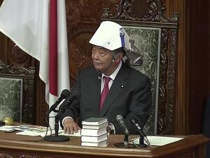 Tadamori Oshima, the lower house speaker, pictured yesterday donning his own white helmet, told the representatives that he always wanted them to be alert. 'You never know when disaster will strike,' he said  (Daily Mail)