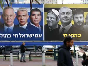 A billboard with Blue and White alliance leaders with Benny Gantz in the centre and another on the right showing Prime Minister Benjamin Netanyahu flanked by right-wing allies. (Jack Guez, AFP)