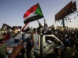 Sudanese protesters wave national flags as they gather near the military headquarters in the capital Khartoum, during a rally on April 27, 2019. AFP