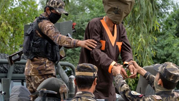 Forces with Afghanistan's National Directorate of Security (NDS) escort an alleged militant as Taliban and Islamic State (IS) fighters are presented to the media in Jalalabad on May 23, 2019. (AFP/ File Photo)