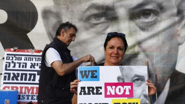 A woman holds a banner as Israeli opposition parties' supporters attend a rally against Prime Minister Benjamin Netanyahu on May 25, 2019 in the coastal city of Tel Aviv. (JACK GUEZ / AFP)