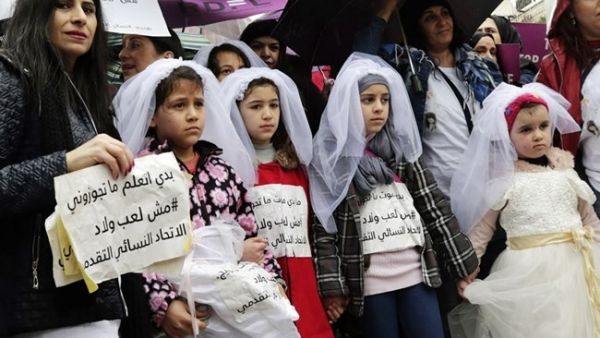 Young Lebanese girls hold placards as they participate in a march against early marriage in Beirut, March 2, 2019. (AFP / ANWAR AMRO)