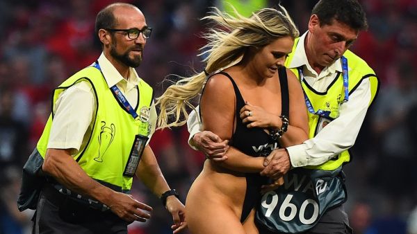 Stewards escort a pitch invader during the UEFA Champions League final football match between Liverpool and Tottenham Hotspur at the Wanda Metropolitano Stadium in Madrid on June 1, 2019.  GABRIEL BOUYS / AFP