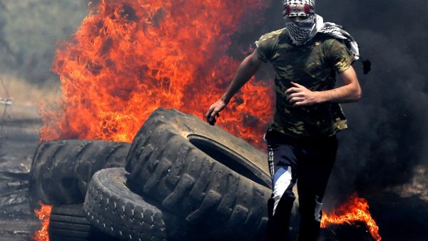 A Palestinian protester runs for cover while being chased by Israeli security forces during a weekly demonstration against the expropriation of Palestinian lands by Israel in the village of Kfar Qaddum, near Nablus in the occupied West Bank on June 7, 2019. (JAAFAR ASHTIYEH / AFP)