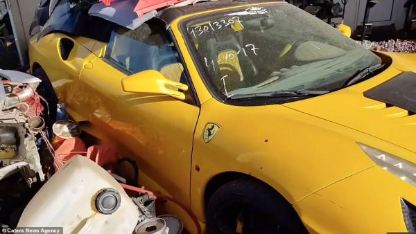 A bright yellow Ferrari is covered with assorted pieces of plastic waste and has a date written on its front windscreen at the yard full of abandoned vehicles in Sharjah in the UAE. (Daily Mail)