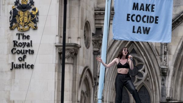 Singer Jessica Winter entertains demonstrators from the "Extinction Rebellion" climate environmental activist group protesting outside of The Royal Courts of Justice on The Strand in central London in London on July 15, 2019. (Niklas HALLE'N / AFP)