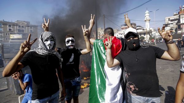 Masked protesters flash the victory gesture as they block the main road outside the Palestinian refugee camp of Burj al-Barajneh, south of the Lebanese capital Beirut, on July 16, 2019. (AFP/ File Photo)