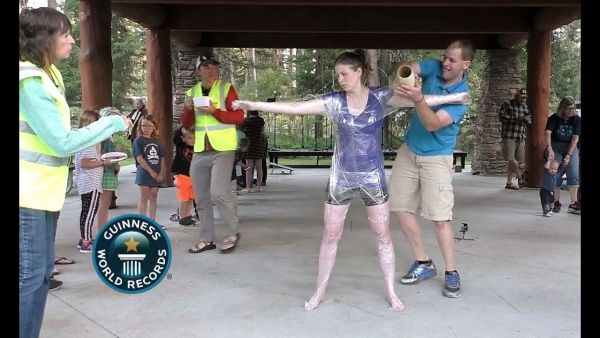 Idaho man covers wife in plastic wrap for Guinness World Record. (Video Screenshot)